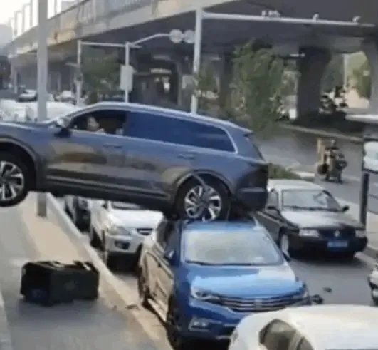 女子倒车不当悬空压在路边车顶，在路边倒车顶了别人车！责任如何定？