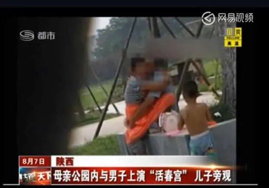 母亲与男子在公园上演：儿子一旁玩耍（图）